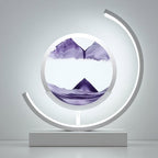 A modern circular LED light sculpture on a rectangular base, featuring a clear dome with purple watercolor mountain scenery inside, set against a minimalist gray background.