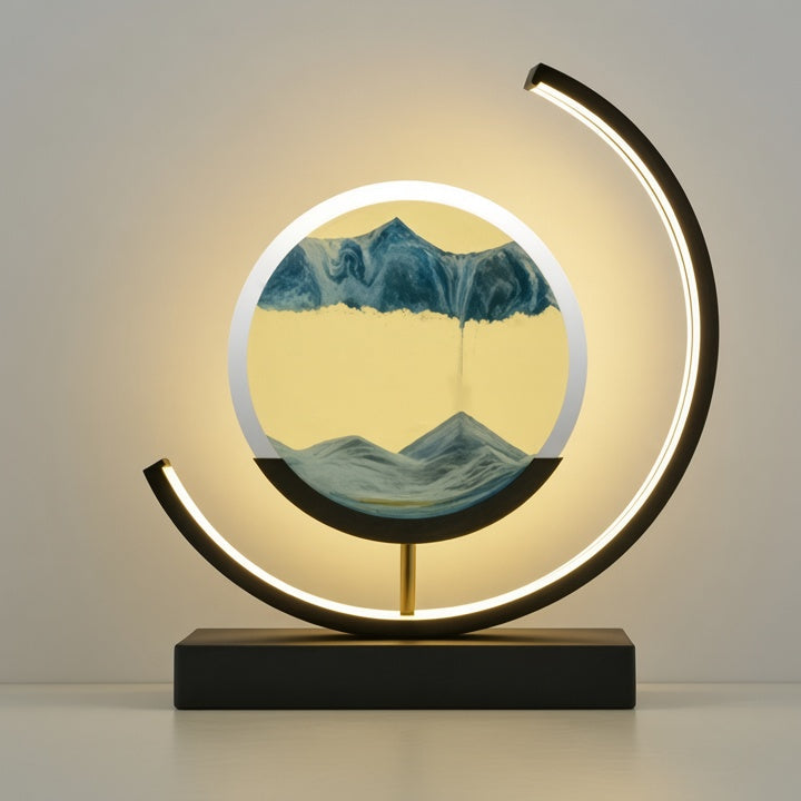 A modern LED arc lamp with a circular acrylic display showing a mountain landscape, mounted on a black rectangular base with a gold support rod.